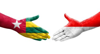 Ellere boyanmış Endonezya ve Togo bayrakları arasındaki el sıkışma, izole şeffaf görüntü.