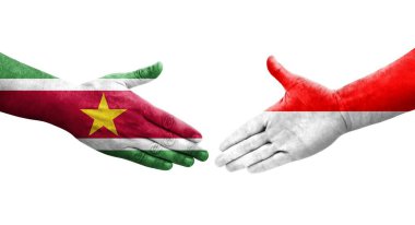 Ellere boyanmış Endonezya ve Surinam bayrakları arasındaki el sıkışma, izole şeffaf görüntü.