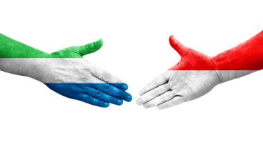 Endonezya ve Sierra Leone bayrakları arasındaki el sıkışma ellerinde izole şeffaf görüntü.