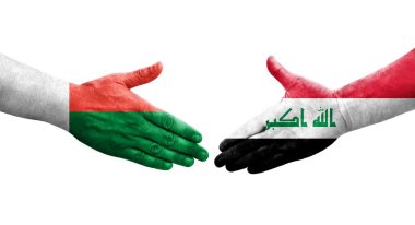 Irak ve Madagaskar bayrakları arasındaki el sıkışma, izole edilmiş şeffaf görüntü.