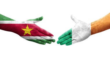 İrlanda ile Surinam bayrakları arasındaki el sıkışma, izole şeffaf görüntü.