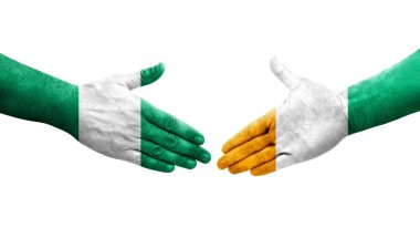 Fildişi Sahilleri ve Nijerya bayrakları arasındaki el sıkışma ellerinde izole şeffaf görüntü.