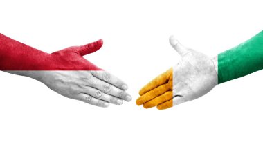 Fildişi Sahilleri ve Monako bayrakları arasındaki el sıkışma, izole şeffaf görüntü.