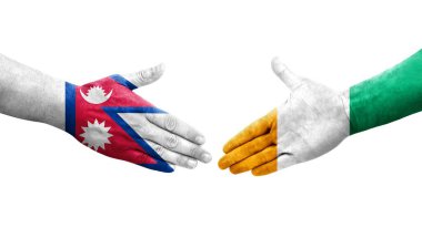 Fildişi Sahilleri ve Nepal bayrakları arasındaki el sıkışma ellere boyanmış, izole saydam görüntü.