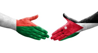 Ürdün ve Madagaskar bayrakları arasındaki el sıkışma ellerde resmedilmiş, şeffaf görüntü.