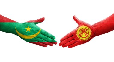 Kırgızistan ve Moritanya bayrakları arasındaki el sıkışma ellerinde izole şeffaf görüntü.