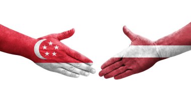 Letonya ve Singapur bayrakları arasındaki el sıkışma ellerinde boyalı, izole şeffaf görüntü.