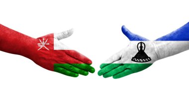 Lesotho ve Umman bayrakları arasındaki el sıkışma ellere boyanmış, izole şeffaf görüntü.