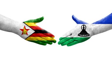 Lesotho ve Zimbabwe bayrakları arasındaki el sıkışma ellerinde izole şeffaf görüntü.