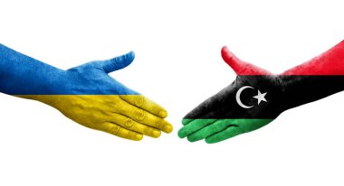 Libya ve Ukrayna bayrakları arasındaki el sıkışma, izole şeffaf görüntü.