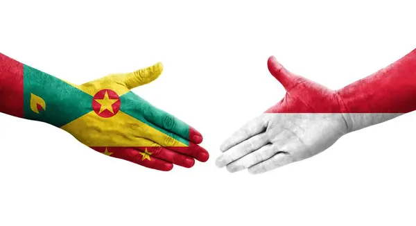 Stock image Handshake between Grenada and Monaco flags painted on hands, isolated transparent image.