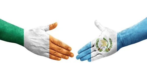 手に描かれたグアテマラとアイルランドの旗の間の握手 孤立した透明なイメージ — ストック写真