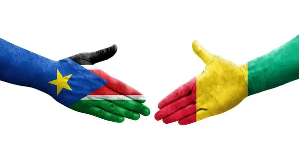 stock image Handshake between Guinea and South Sudan flags painted on hands, isolated transparent image.