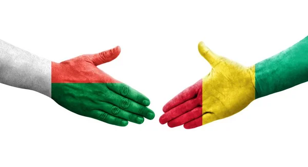 Handdruk Tussen Guinee Madagaskar Vlaggen Geschilderd Handen Geïsoleerd Transparant Beeld — Stockfoto