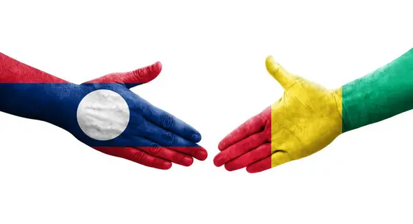 stock image Handshake between Guinea and Laos flags painted on hands, isolated transparent image.