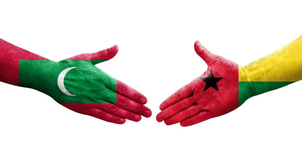 stock image Handshake between Guinea Bissau and Maldives flags painted on hands, isolated transparent image.