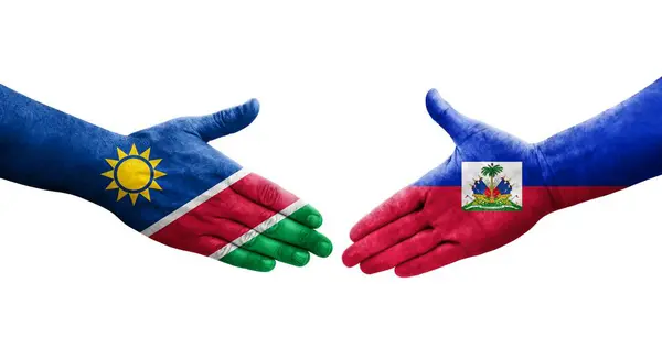 stock image Handshake between Haiti and Namibia flags painted on hands, isolated transparent image.