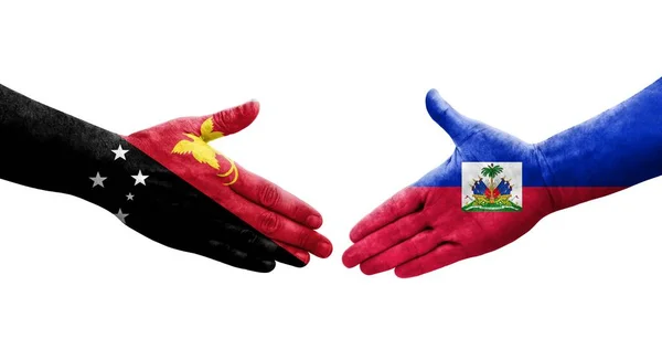 stock image Handshake between Haiti and Papua New Guinea flags painted on hands, isolated transparent image.