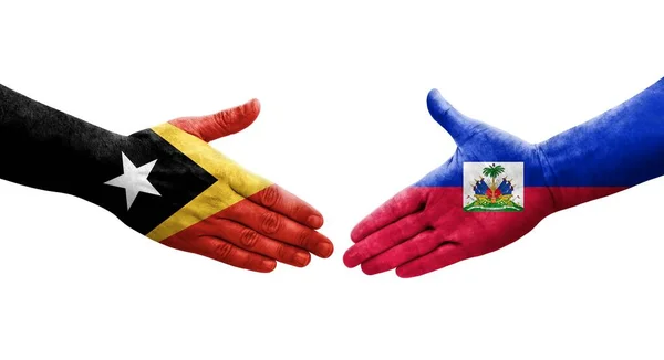 手に描かれたハイチと東ティモールの旗の間の握手 孤立した透明なイメージ — ストック写真