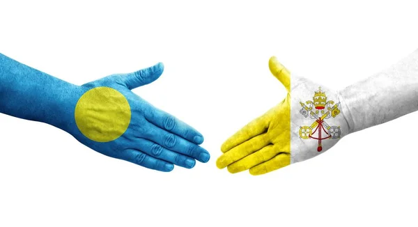 stock image Handshake between Holy See and Palau flags painted on hands, isolated transparent image.