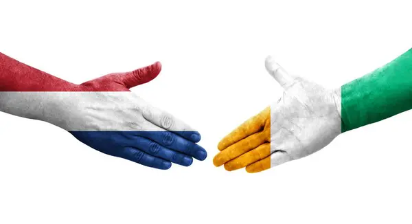 Handdruk Tussen Ivoorkust Nederlandse Vlaggen Handen Geschilderd Geïsoleerd Transparant Beeld — Stockfoto