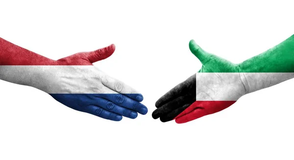 手に描かれたクウェートとオランダの旗の間の握手 隔離された透明なイメージ — ストック写真