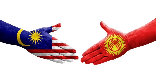 stock image Handshake between Kyrgyzstan and Malaysia flags painted on hands, isolated transparent image.