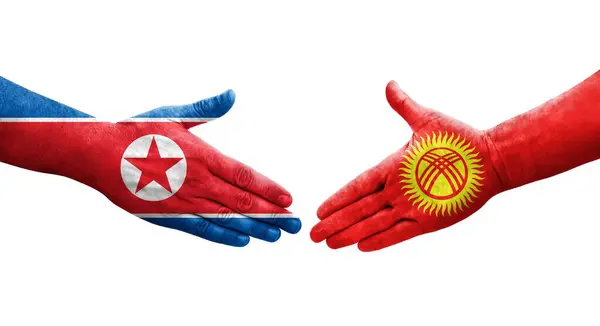 Händedruck Zwischen Kirgisischen Und Nordkoreanischen Flaggen Auf Hände Gemalt Isoliertes — Stockfoto