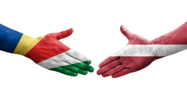 Handslag Mellan Lettland Och Seychellerna Flaggor Målade Händer Isolerad Transparent — Stockfoto