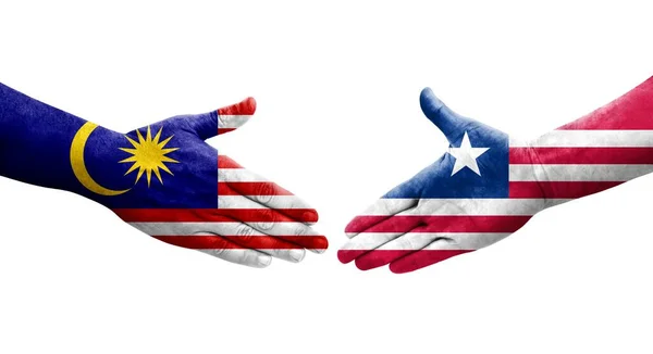 stock image Handshake between Liberia and Malaysia flags painted on hands, isolated transparent image.