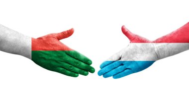 Lüksemburg ve Madagaskar bayrakları arasındaki el sıkışma, izole şeffaf görüntü.