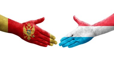 Lüksemburg ve Karadağ bayrakları arasında el sıkışma, el yazısı ve izole edilmiş şeffaf görüntü.