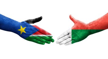 Madagaskar ve Güney Sudan bayrakları arasındaki tokalaşma elleri boyalı, izole şeffaf görüntü.
