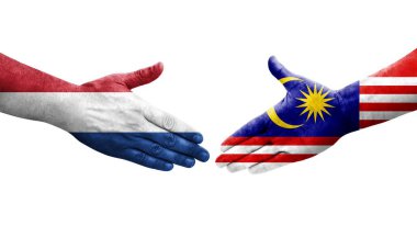 Ellere boyanmış Malezya ve Hollanda bayrakları arasındaki el sıkışma, izole şeffaf görüntü.
