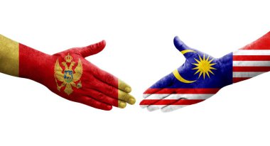 Ellere boyanmış Malezya ve Karadağ bayrakları arasındaki el sıkışma, izole edilmiş şeffaf görüntü.