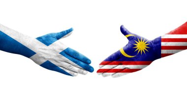 Ellere boyanmış Malezya ve İskoçya bayrakları arasındaki el sıkışma, izole şeffaf görüntü.