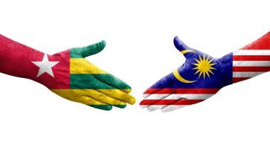 Ellere boyanmış Malezya ve Togo bayrakları arasındaki el sıkışma, izole şeffaf görüntü.