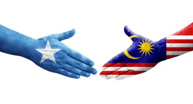 Ellere boyanmış Malezya ve Somali bayrakları arasındaki el sıkışma, izole şeffaf görüntü.