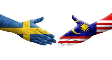Ellere boyanmış Malezya ve İsveç bayrakları arasındaki el sıkışma, izole şeffaf görüntü.
