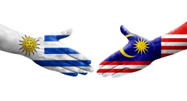 Malezya ve Uruguay bayrakları arasındaki el sıkışma ellerinde izole şeffaf görüntü.