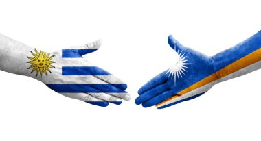 Marshall Adaları ve Uruguay bayrakları arasındaki el sıkışma ellerinde izole şeffaf görüntü.