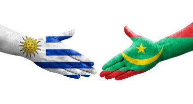 Moritanya ve Uruguay bayrakları arasındaki el sıkışma ellerinde izole şeffaf görüntü.