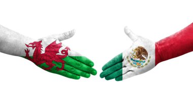 Meksika ve Galler arasındaki el sıkışma ellerinde boyalı bayraklar, izole edilmiş şeffaf görüntü.