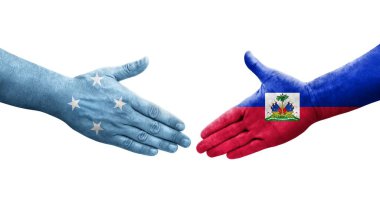 Mikronezya ve Haiti bayrakları arasındaki el sıkışma ellerinde izole şeffaf görüntü.