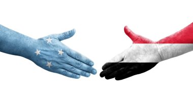 Mikronezya ve Yemen bayrakları arasındaki el sıkışma ellerinde izole şeffaf görüntü.