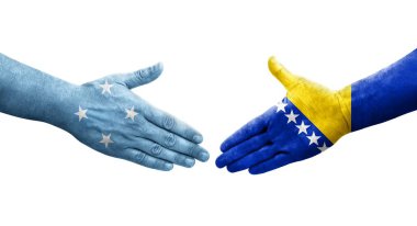 Mikronezya ile Bosna bayrakları arasındaki el sıkışma, izole edilmiş şeffaf görüntü.