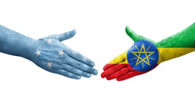 Mikronezya ve Etiyopya bayrakları arasındaki el sıkışma ellerinde izole şeffaf görüntü.