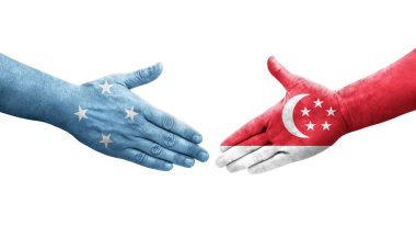 Mikronezya ve Singapur bayrakları arasındaki el sıkışma ellerinde izole şeffaf görüntü.
