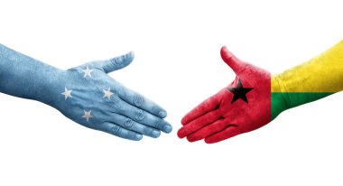Mikronezya ve Gine Bissau bayrakları arasındaki el sıkışma ellerinde resmedilmiş şeffaf görüntü.