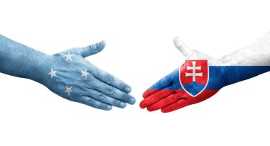Mikronezya ve Slovakya bayrakları arasındaki el sıkışma ellerinde izole şeffaf görüntü.